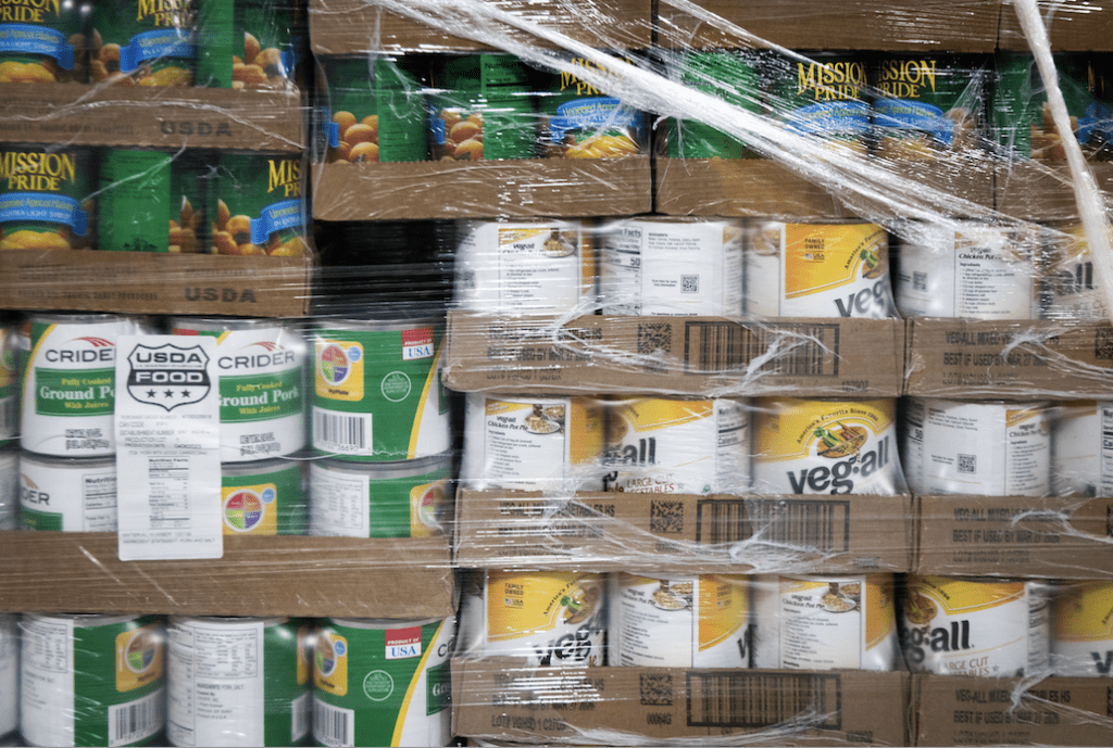 A palette of canned goods wrapped in plastic is ready for shipment or storage.