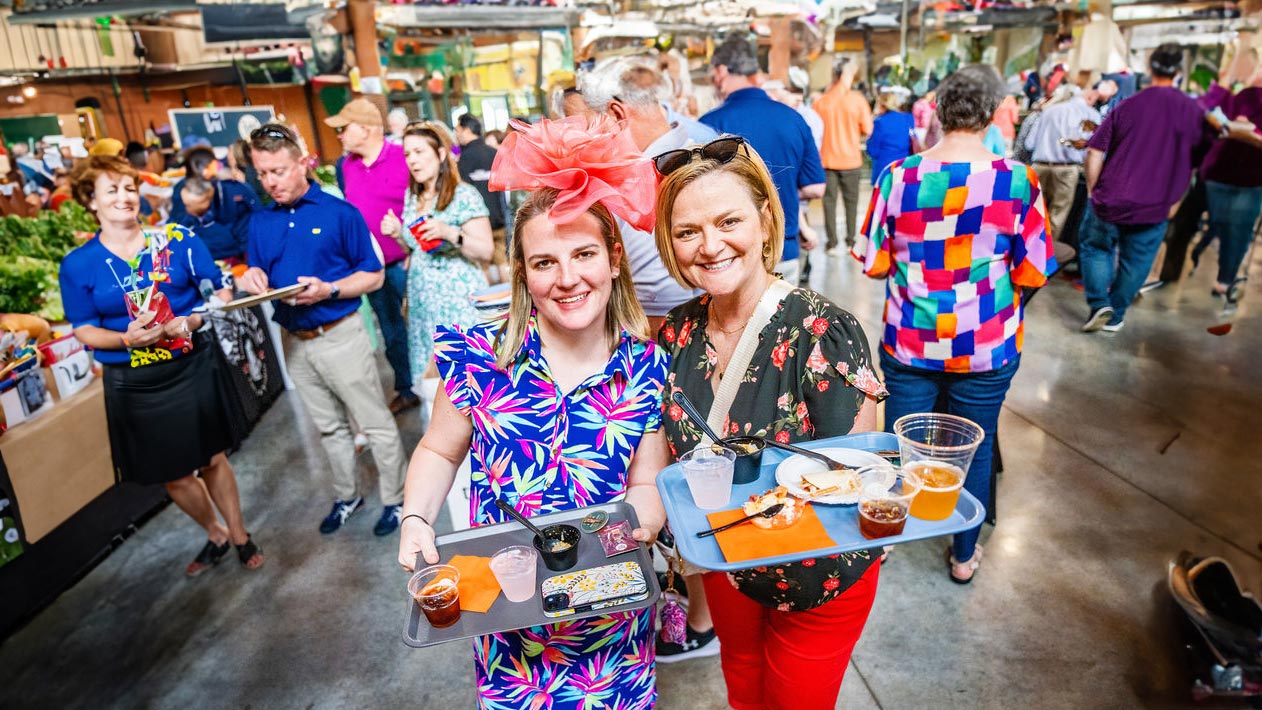 Women holding trays of food and drinks at a derby event